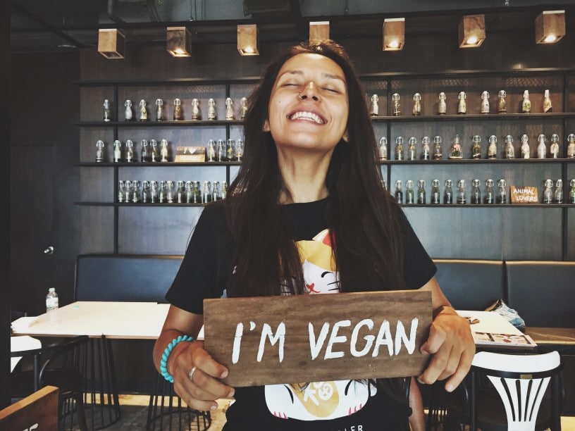 vegan-girl-smiling-holding-sign-healthy-lifestyle
